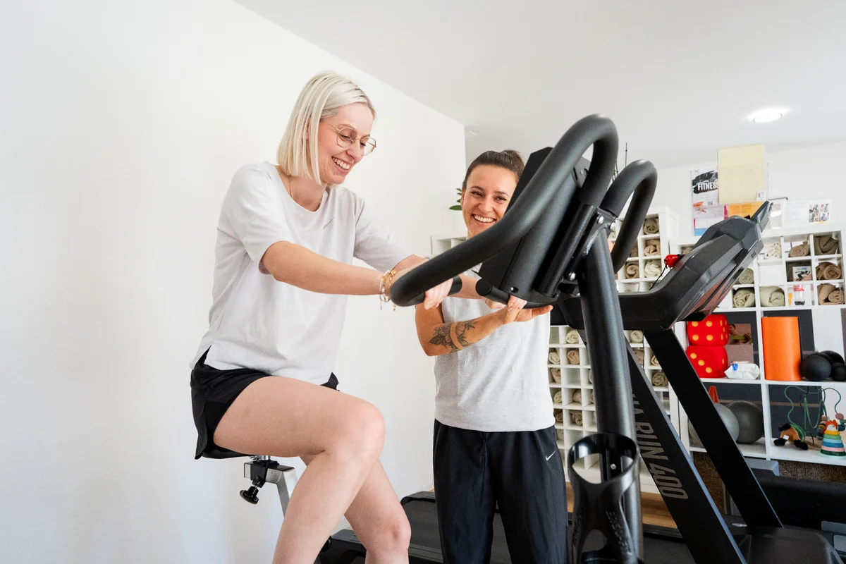Nahaufnahme einer physiotherapeutischen Behandlung am Knie oder an der Hand; konzentrierte, fachkundige Geste der Therapeutin; heller, ruhiger Hintergrund