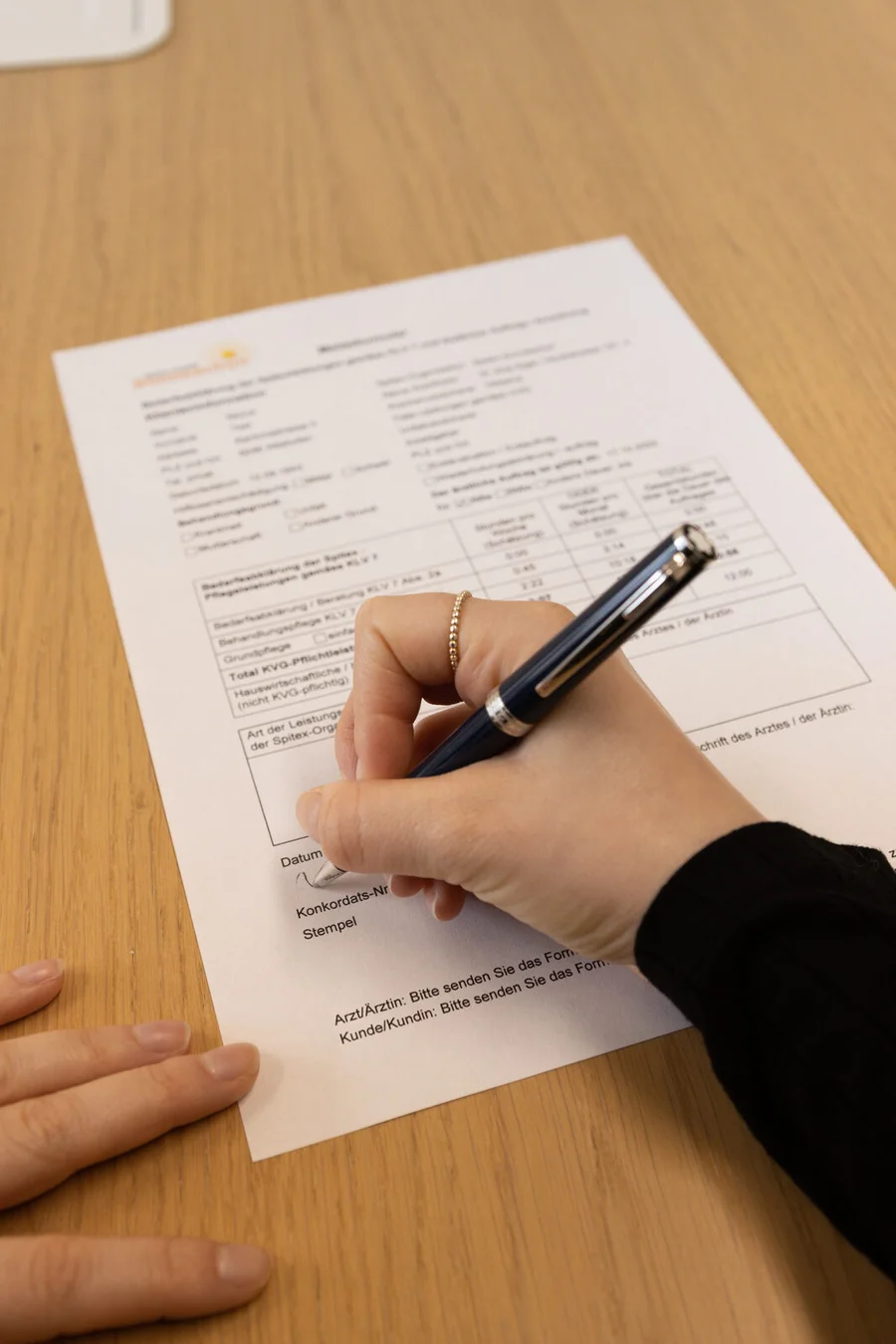 Fachperson und Klient:in sichten gemeinsam Unterlagen am Tisch